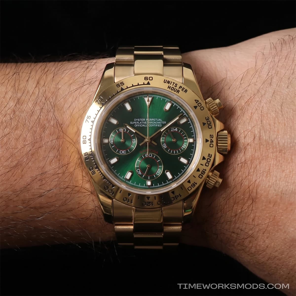 Orologio cronografo dorato con quadrante verde al polso