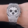 Reloj cronógrafo de acero con esfera blanca en muñeca