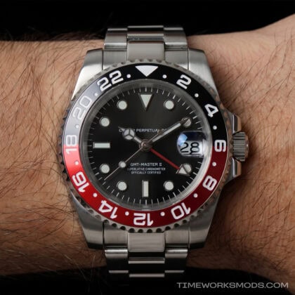 Reloj GMT rojo y negro en muñeca masculina