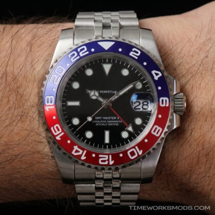 Reloj GMT deportivo de acero en muñeca masculina
