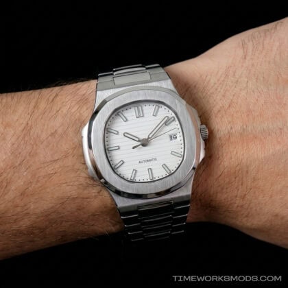 Reloj automático de acero con esfera blanca en muñeca