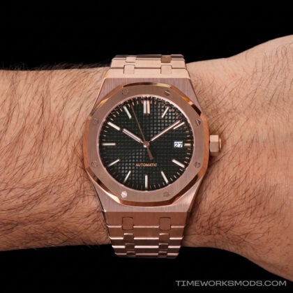Reloj automático dorado con esfera negra en la muñeca