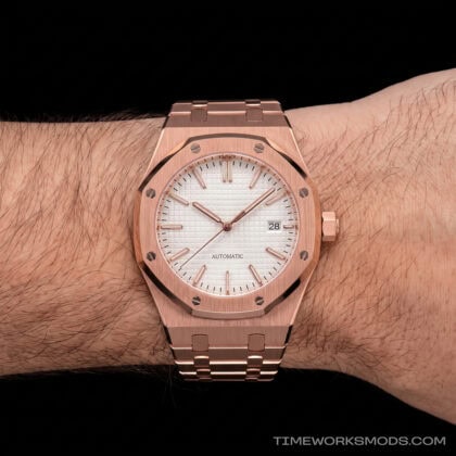 Reloj automático dorado con esfera clara en la muñeca