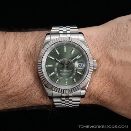 Reloj de pulsera plateado con esfera verde en muñeca