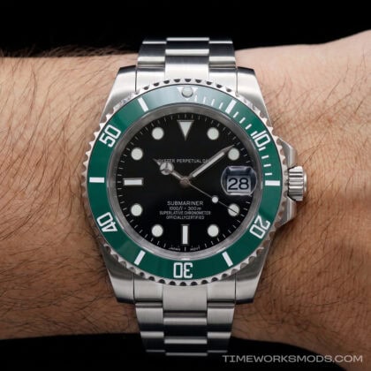 Reloj de buceo acero con bisel verde en la muñeca