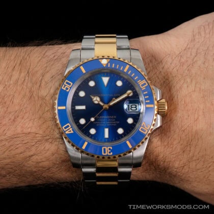 Reloj de buceo azul y dorado en la muñeca