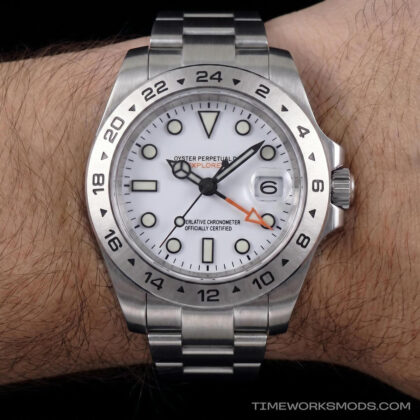 Reloj deportivo de acero con esfera blanca en la muñeca