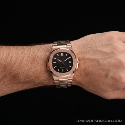 Reloj de pulsera dorado con esfera negra en muñeca